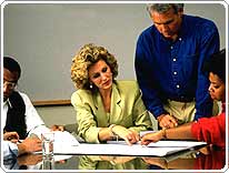 people in a meeting looking over papers