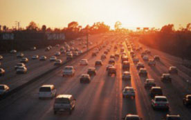 Figure 6: Photo: Moderate vehicular traffic on a highway with sun in distance.
