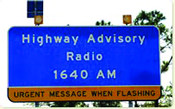 Photograph of blue highway sign reading 'Highway Advisory Radio 1640 AM, Urgent Message When Flashing'