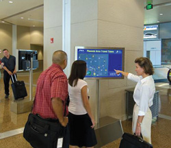 Woman pointing at traveler information display at airport