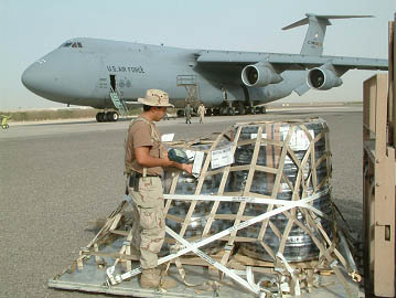 photo of a soldier scanning an active RFID tag on palletized cargo next to an airstrip