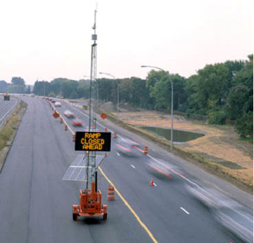 photo of a portable traffic control device with the message "ramp closed ahead" on a highway shoulder