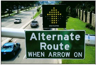 Sign above freeway indicating alternate route should be used when directional arrow is illuminated.