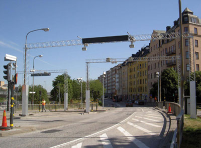 Photo. A road in Stockholm, Sweden where electronic tag readers and cameras have been installed on overhead gantries as part of a cordon pricing program.