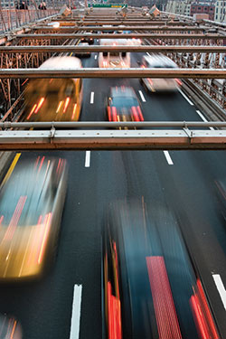 Photo. Overhead view of traffic driving across a bridge.