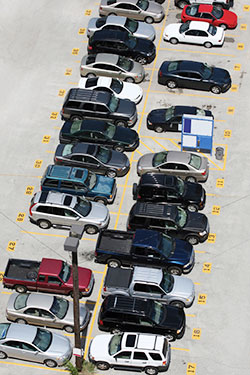 Photo. View from above of cars parked in a lot with numbered parking spaces.