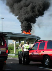 Incident responders monitoring a burning vehicle on Interstate 4 in the Orlando, Florida area.