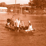 People on a motor boat in a flooding river 