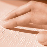 a hand reading Braille text on a page