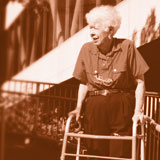 Older woman using a walker to walk down the street