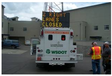 Photo of an incident response truck with a DMS mounted on the cab that reads '2 right lanes closed.' The truck carries the WSDOT logo.