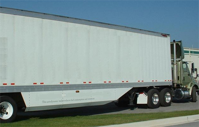 Picture of a truck showing side fairings underneath the trailer and an air dam above the cab.