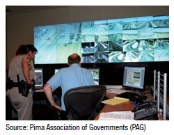 Photo of a police officer and a staff person viewing monitors at a traffic control center. Source: Pima Association of Governments (PAG)