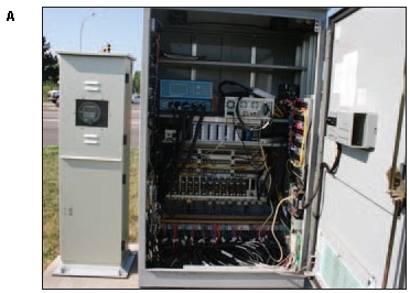 Photo of an open signal control box at an intersection showing a variety of wires and circuits.