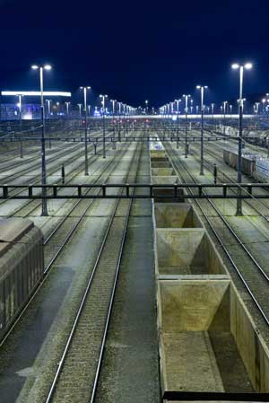 Figure 2.3 is a photograph showing a rail yard illuminated using flat-lens lighting fixtures that direct light downward, reducing light pollution and glare.
