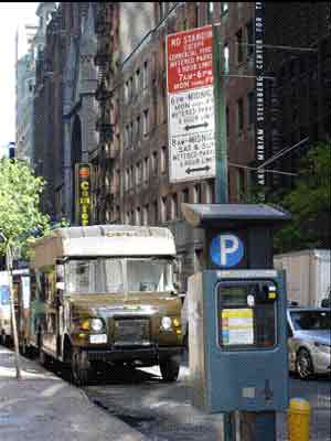 Figure 4.1 is a photograph of a sign that specifies commercial loading and parking rules, and a “Muni-Meter” parking payment kiosk alongside a curb in New York City.