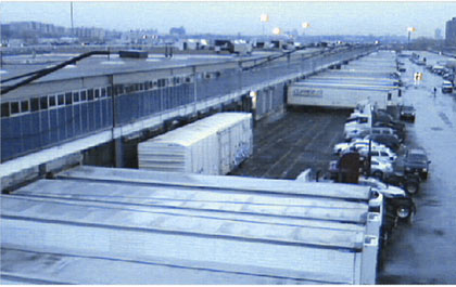Figure 4.3 is a photograph of a rail car parked adjacent to a warehouse loading dock, which is stranded because highway trailers have are parked across the tracks to access other loading docks attached to the same building.