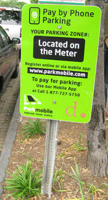 Photo of a green pay-by-phone parking sign.