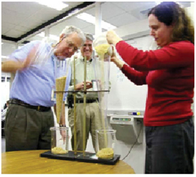 Transportation officials using a funnel and rise apparatus to illustrate the effect of transportation management on congestion.