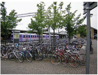 Hundreds of bicycles at a special parking area near public transit stop.