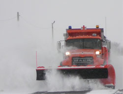 Figure CO-1 is a photo of a truck with a 14-foot wide front plow.