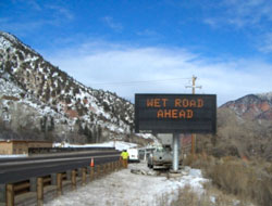 Photo of a variable message sign that reads, Wet Road Ahead.