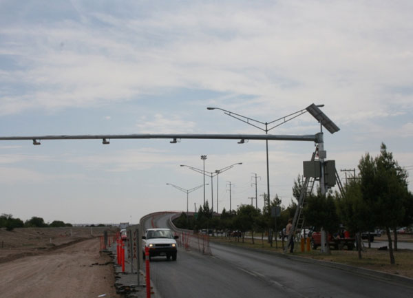 Figure 22. Photo. RFID antennae at the convergence of Boulevard Cuatro Siglos and MX45. This photo shows hardware being installed on the Ciudad Juárez side, specifically the radio frequency identification (RFID) antennae at Boulevard Cuatro Siglos and MX45. Roadway construction is in progress at the site.