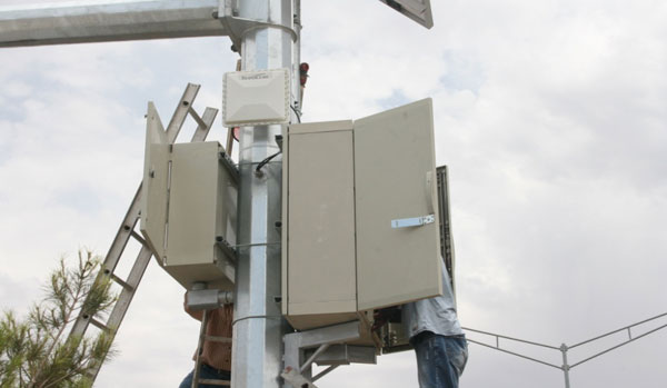 Figure 23. Photo. Contractors installing cabinets on a pole in Ciudad Juárez, Mexico. This photo shows hardware being installed on the Ciudad Juárez side, specifically cabinets on a pole.