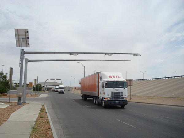 Figure 26. Photo. Truck leaving the State inspection facility on the US side of the border and passing under the RFID reader station. This photo shows hardware installed on the El Paso side. Tractor-trailers leave the State inspection facility and pass under the radio frequency identification (RFID) reader station.