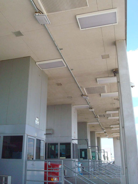 Figure 36. Photo. Installed RFID equipment at CBP's primary inspection facility at Pharr-Reynosa border crossing. This photo shows completed installation of radio frequency identification (RFID) equipment at the primary inspection booths. A panel antenna was mounted over each lane, and a reader was installed in between two lanes. Radio frequency coaxial cable was run from the antenna to the reader. The control cable from the reader to the control panel was run inside the conduit. The antennae were mounted slightly to the driver's side of the middle of the lane to increase the probability of detection for worn, damaged, or improperly applied tags. The antennae are slightly canted toward the driver's windshield.