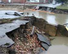 Picture of a roadway which has been broken up by a flood.