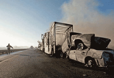 Picture of a burned-out tractor trailer along the side of a highway.