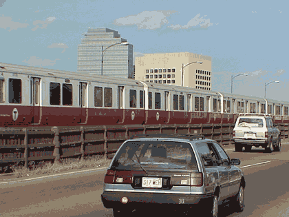 Picture of a rapid transit train running along a highway.