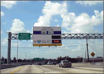 A photograph of an overhead variable message sign indicated the cost for traveling on the roadway with a message of registered carpools free.