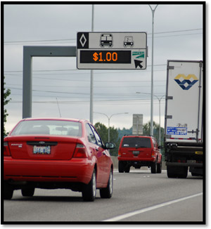 Photo - Photograph of a interstate highway with vehicles traveling under a sign that shows $1 to travel on managed lanes.