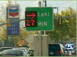 A roadway sign indicating the travel time for the location printed on the sign.