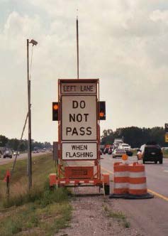 Picture of portable message sign with beacons in a work zone indicating 'Do Not Pass When Flashing.'