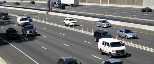 Photo of highway where two left-hand managed lanes are separated from four general purpose lanes using plastic posts.