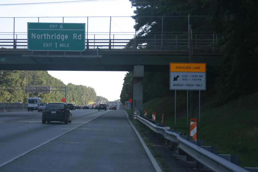 Photo of post-mounted sign on GA 400 on the right shoulder which states, “ Should Lane, 6:30 through 10:00 AM, 4:00 through 7:00 PM, Monday through Friday Only” with an arrow pointing downward and to the left (i.e., towards the part-time shoulder lane).