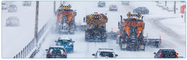 Three snowplows moving abreast conducting plowing and salting activities on an arterial street during a snow storm. Source: Fotolia.