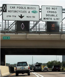 A high-occupancy vehicle lane is separated from normal travel lanes by two thick, white lane marking lines.