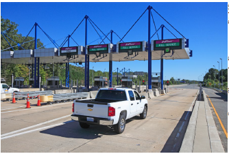 A toll plaza features 3 full service lanes that accept EZPass and cash and one EZPass only lane.