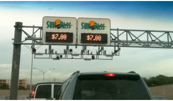 Variable signs mounted on gantries over the travel lanes advise motorists of the current cost for using the tolled SunPass lanes. At the time of this photo, the cost was $7.00.