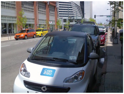 A compact vehicle sporting the Car2Go logo on the hood.