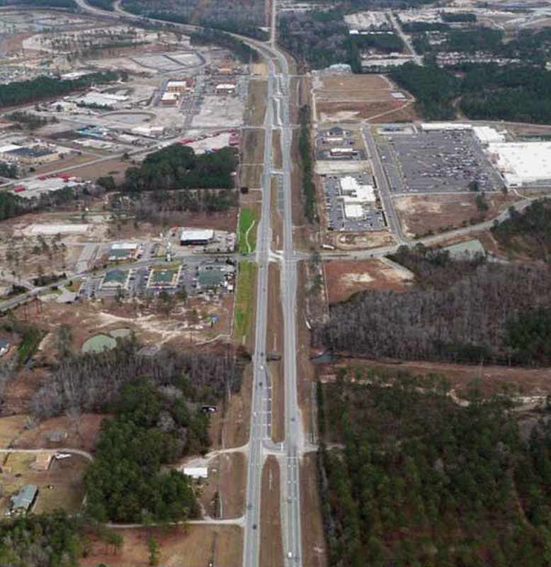 Figure 3 is a photograph of US17 illustrating a restricted crossing U-turn corridor. A north south US 17 cuts across the image with development on either side of the road. Multiple East West minor roads intersect with US 17. These are designed as restricted crossing U-turn corridors.