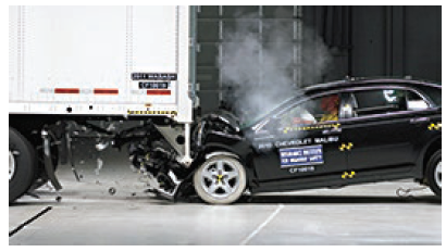 The front end of a car impacts an under-ride guard, comprising a set of bars which extend straight down from the back edge of a semi-trailer to prevent smaller vehicles from being propelled underneath the trailer due to a crash impact. The passenger compartment is not impacted by the crash in this photo.