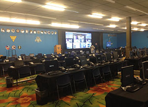 The New Jersey Department of Transportation Command Center features rows of desks and desktop information consoles as well as a bank of wall-mounted television screens.