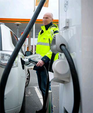photo of a service station attendant charging an electric vehicle
