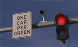 Figure 22 is a photo of a ramp meter. It shows a bar, presumably hanging over a highway on-ramp, with a signal, camera, and a sign that reads "one car per green."