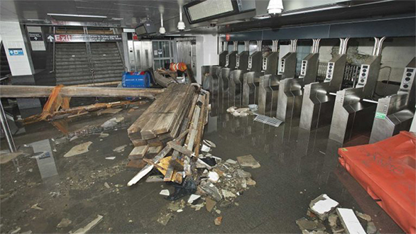 Figure 4. Photo of a flooded subway station, near the turnstiles with debris amassing in the water.